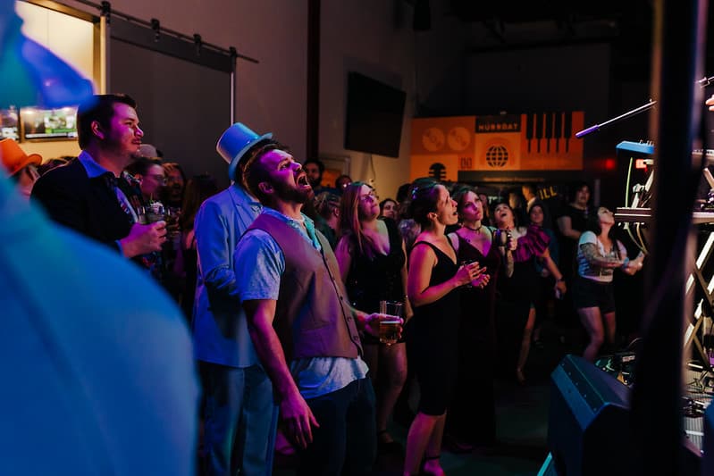 Crowd dancing while the band plays on stage