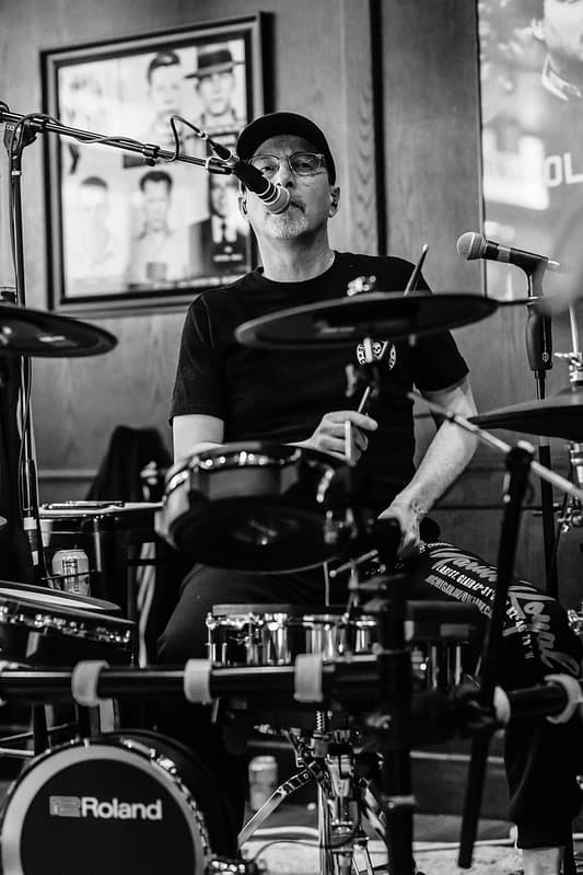 Drummer behind the Roland kit in black and white