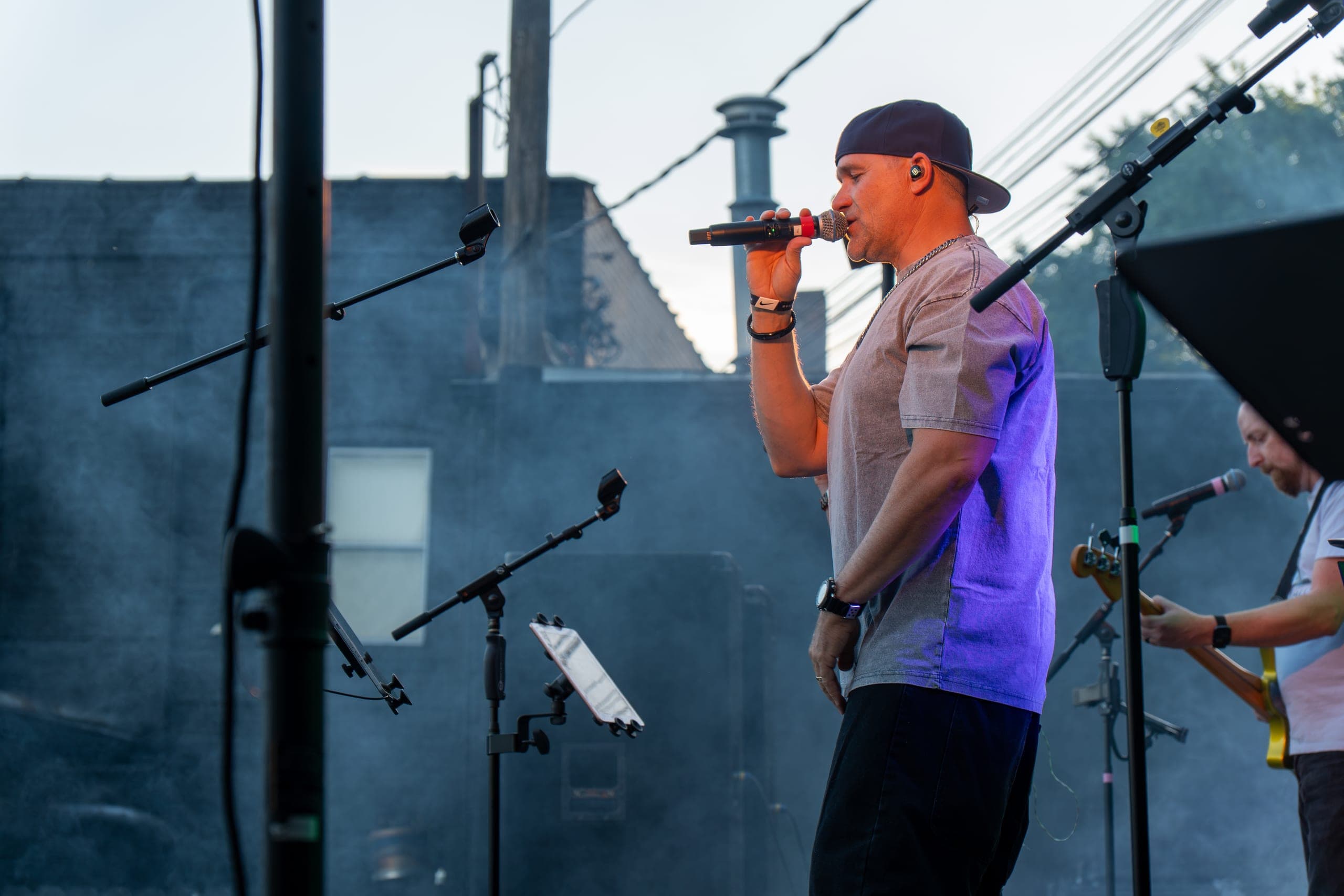 Vocalist singing in profile during an outdoor set at golden hour