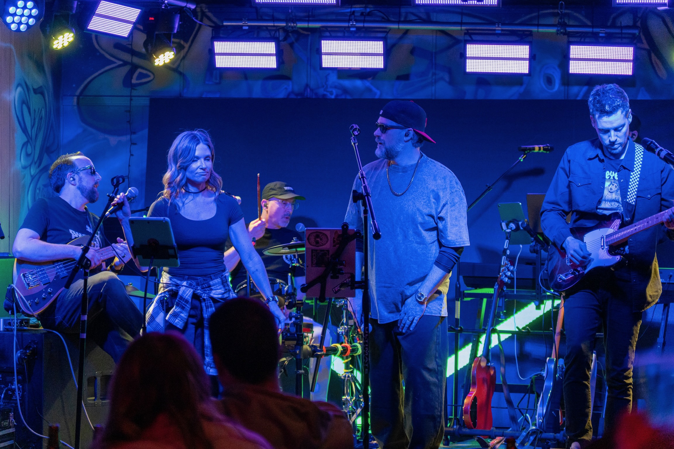 Full band rocking out under colored stage lights